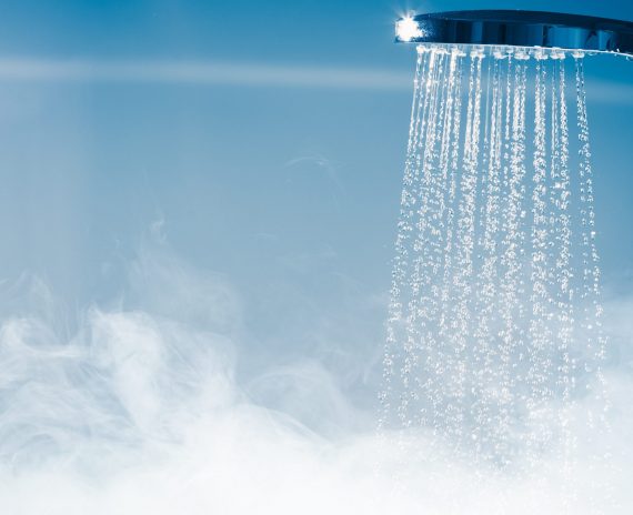 A shower head with water pouring out of it.