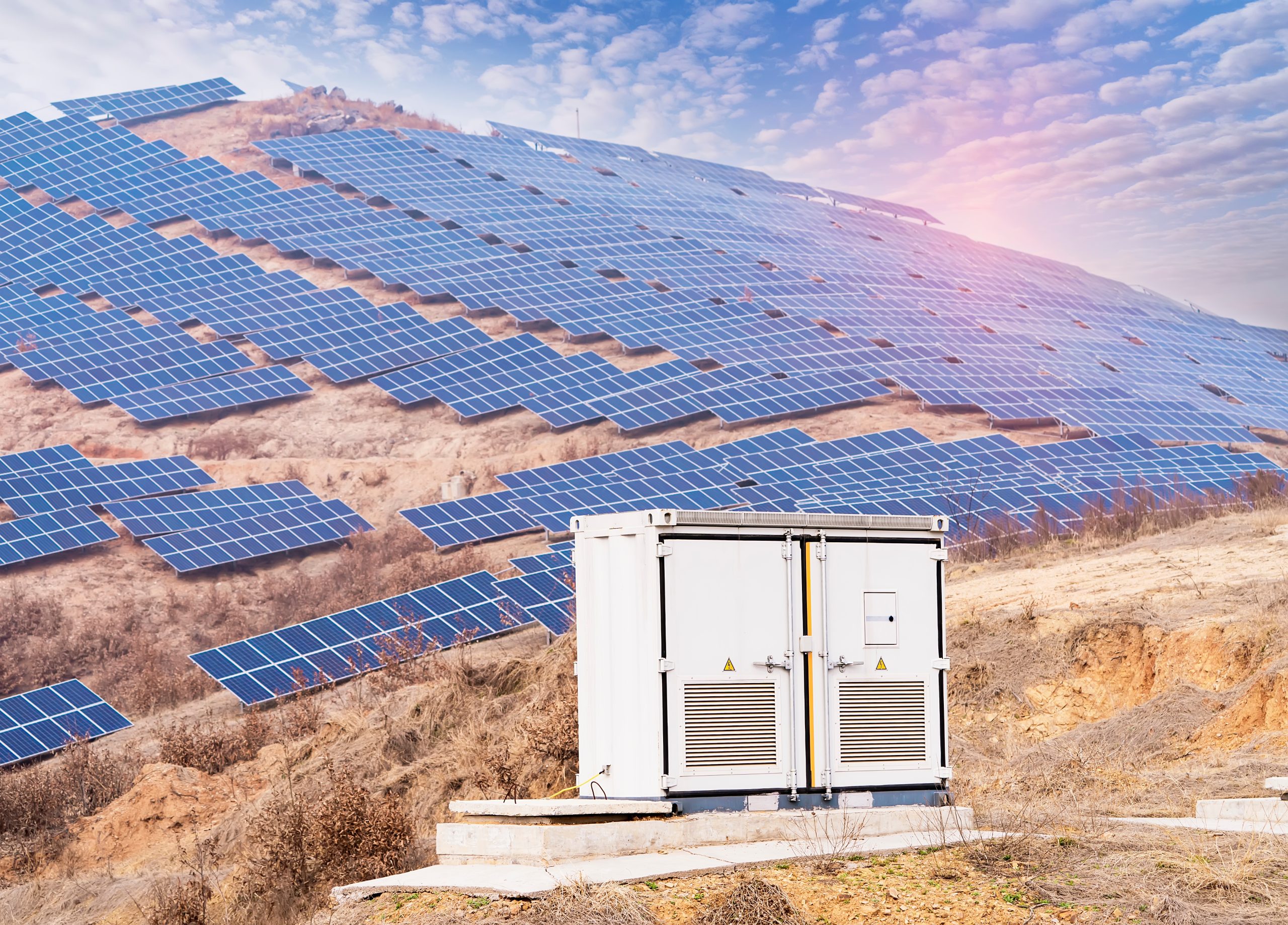 Solar panels on a hillside with battery storage units